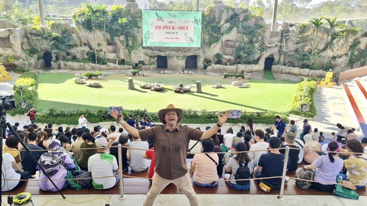 Rico Smith with arms wide open in front of a packed bird show amphitheatre at a family day out