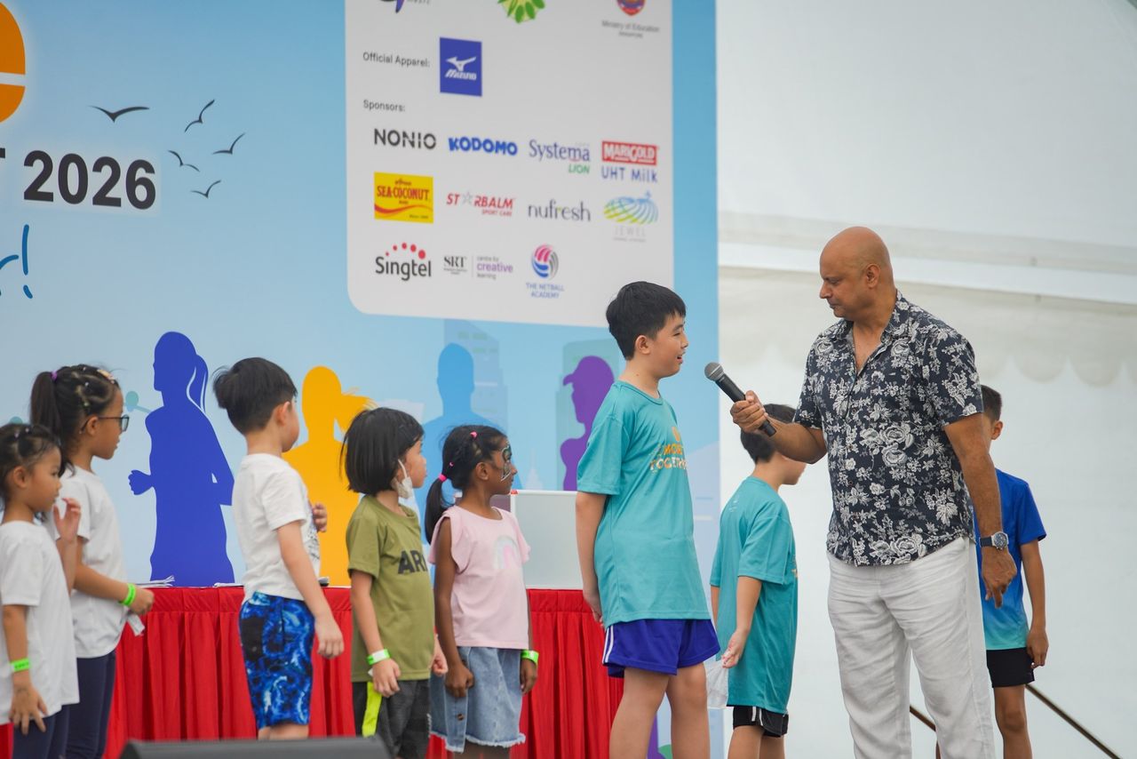 Rico Smith interviewing a young participant on stage at the MOE OLive Run and Family Fest