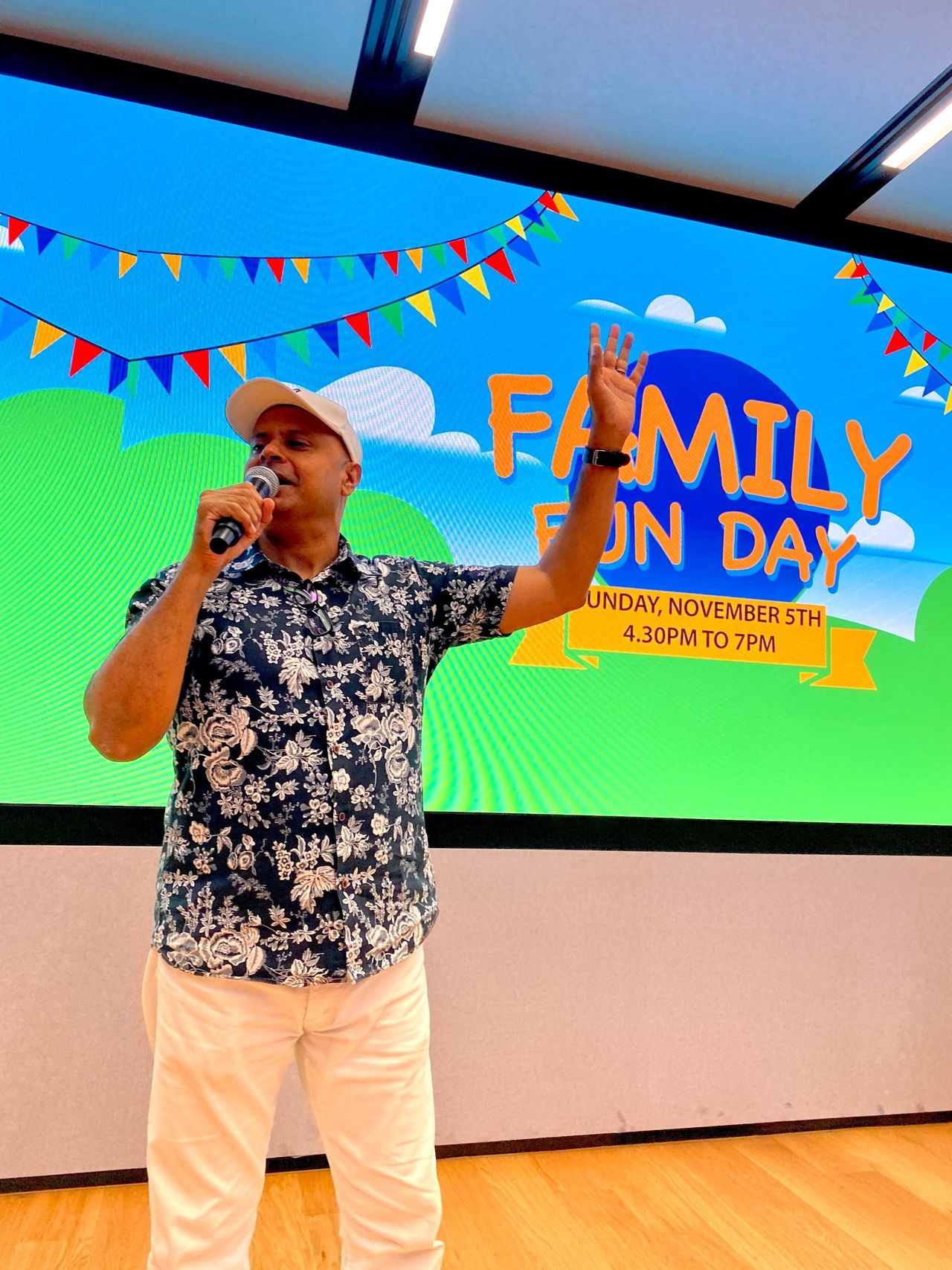 Rico Smith in a cap waving to the crowd at a Family Fun Day