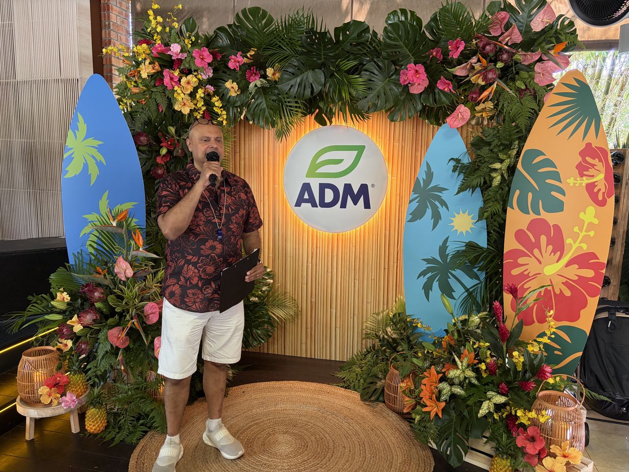 Rico Smith hosting in front of a tropical ADM backdrop
